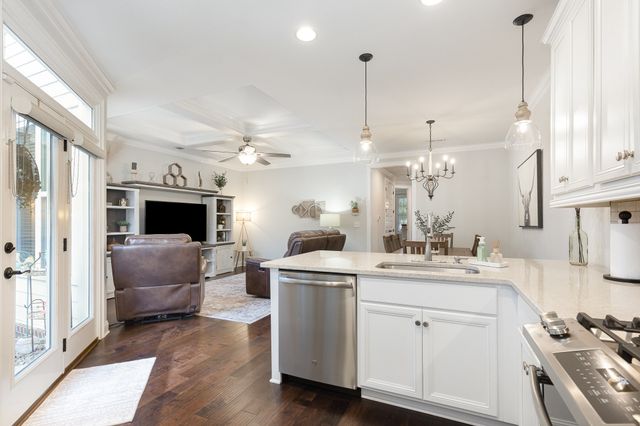 a kitchen with a stove a sink and a wooden floor