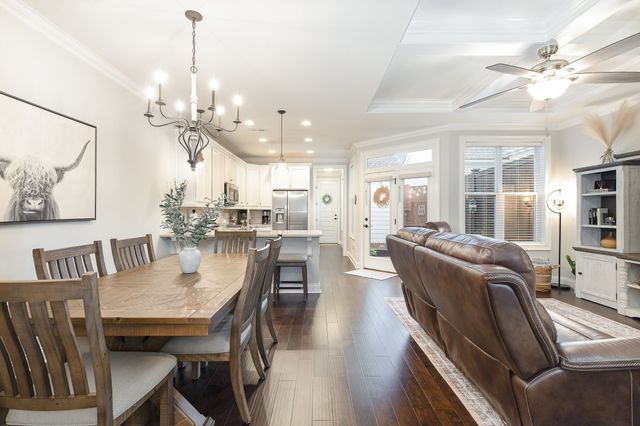 a dining room with furniture a chandelier and wooden floor
