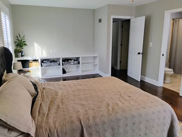 a bedroom with a bed and a potted plant