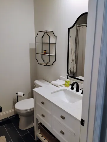 a bathroom with a toilet sink and mirror