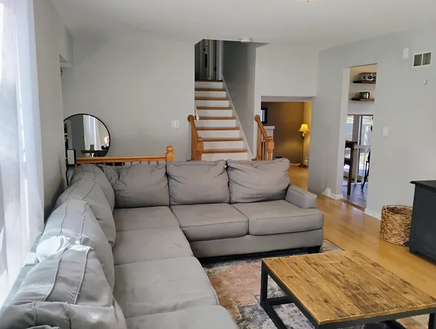 a living room with furniture and wooden floor