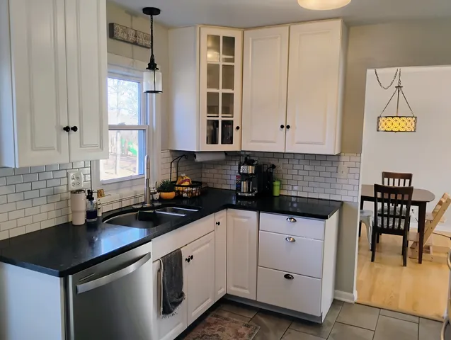 a kitchen with granite countertop a sink a stove and cabinets