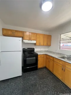 a kitchen with granite countertop a refrigerator and a sink