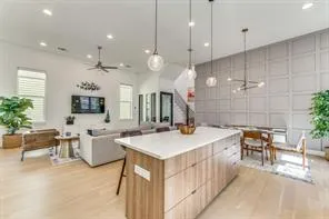 a large kitchen with kitchen island a stove a sink a dining table and chairs with wooden floor