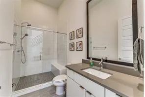 a bathroom with a granite countertop sink toilet and shower