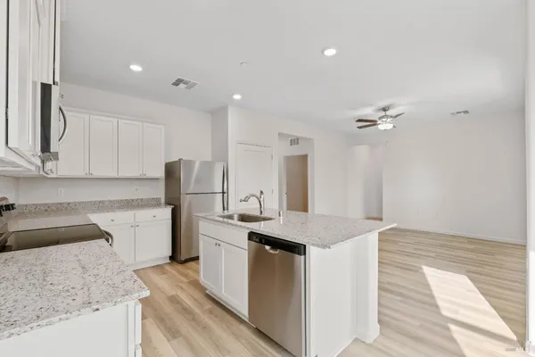 a kitchen with granite countertop cabinets stainless steel appliances a sink and dishwasher