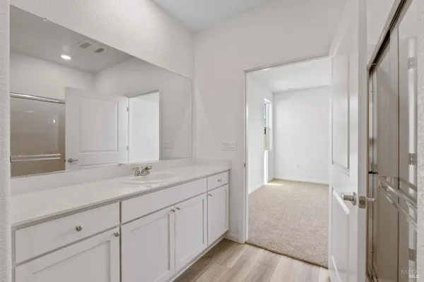 a en suite bathroom with a granite countertop sink and mirror