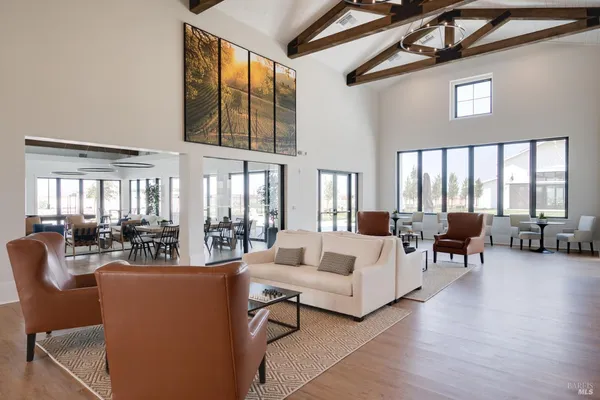 a living room with furniture fireplace and large windows