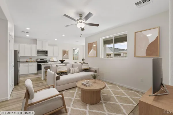 a living room with furniture and a view of kitchen