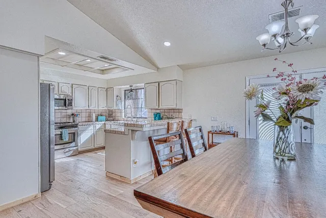 a kitchen with refrigerator and chairs