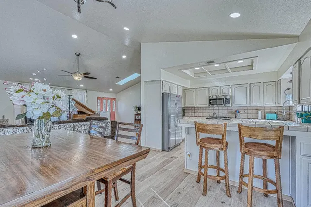 a kitchen with stainless steel appliances granite countertop a sink dishwasher stove top oven and cabinets with wooden floor