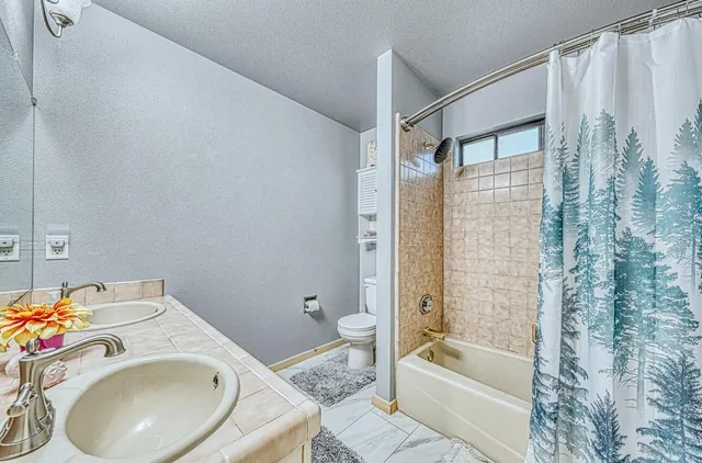 a bedroom with two beds and a large mirror next to a window