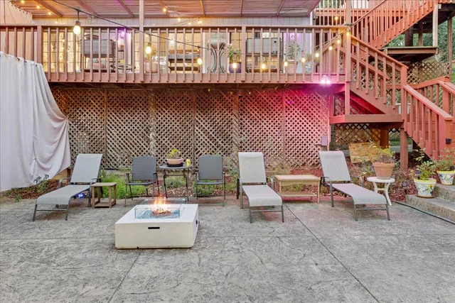 a view of a patio with table and chairs with barbeque and wooden fence