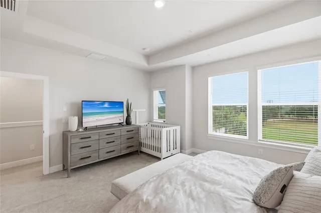 a bed sitting in a bedroom next to a window and a wooden floor