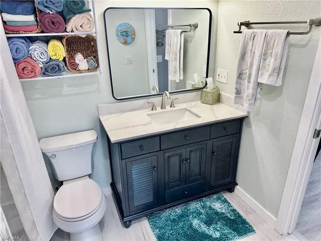 a bathroom with a toilet a sink and a mirror