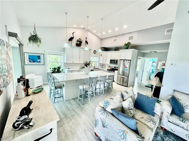 a living room with lots of furniture and kitchen view