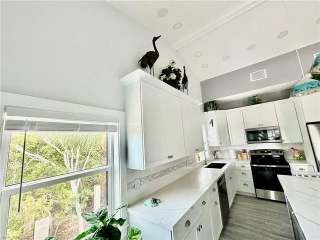 a kitchen with a sink stainless steel appliances and white cabinets
