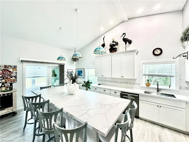 a kitchen with a dining table chairs and white cabinets