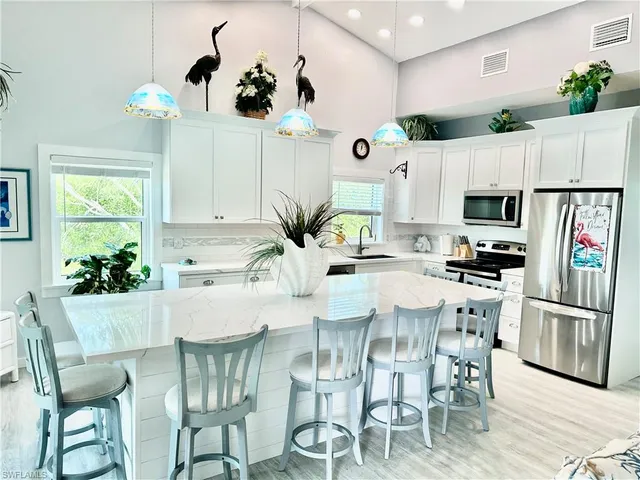 a kitchen with granite countertop stainless steel appliances a table and chairs in it