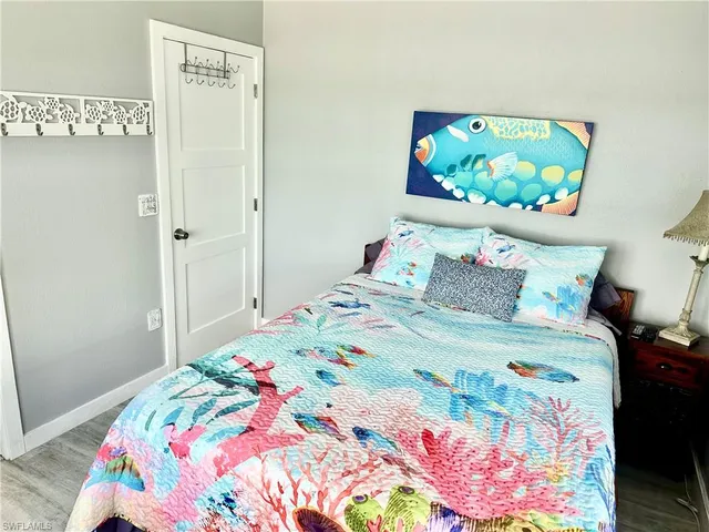 a bedroom with a bed and a painting on the wall