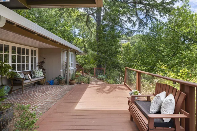 a view of a patio with table and chairs with wooden floor and fence