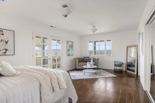 a bedroom with a large bed and wooden floor