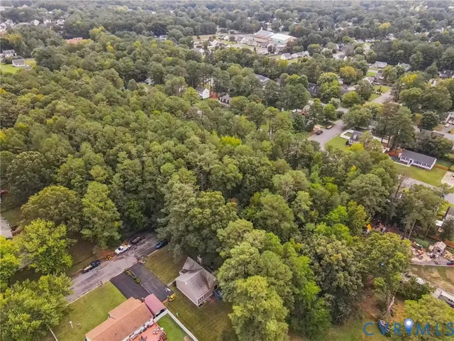 an aerial view of residential house with outdoor space and trees all around