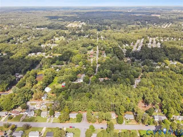 an aerial view of house with yard and mountain view in back