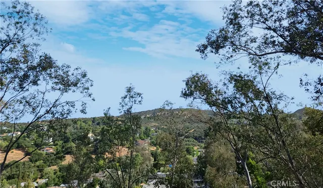 a kitchen with stainless steel appliances kitchen island granite countertop a refrigerator a sink a stove and white cabinets with wooden floor