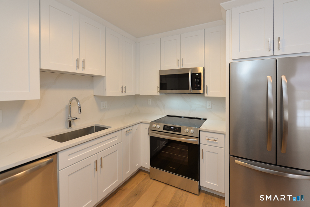 63 Glen Ridge Court, Unit 63 New Milford, CT 06776 - Photo 3 of 12 a kitchen with stainless steel appliances granite countertop a refrigerator stove and sink