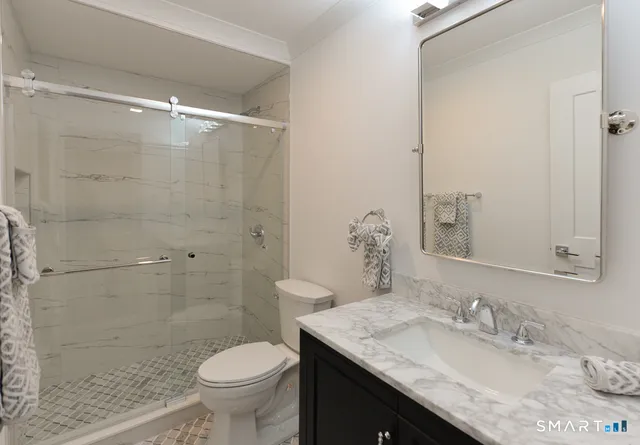 a bathroom with a granite countertop sink toilet and shower