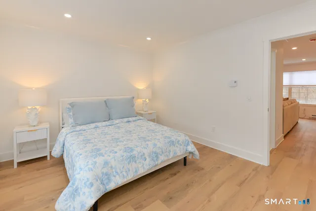 a bedroom with a bed and wooden floor