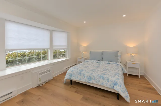 a bedroom with a bed and a large window