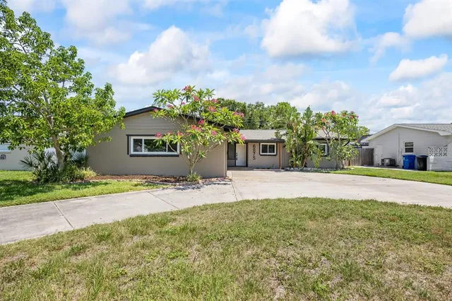 a front view of a house with a yard and trees