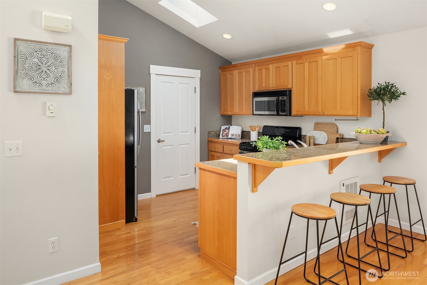 2452 Southwest Webster Street Seattle, WA 98106 - Photo 8 of 28 a kitchen with stainless steel appliances granite countertop a sink a stove a refrigerator a microwave with a dining table and chairs
