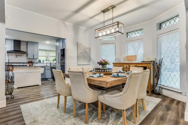 a dining room with furniture a chandelier and wooden floor
