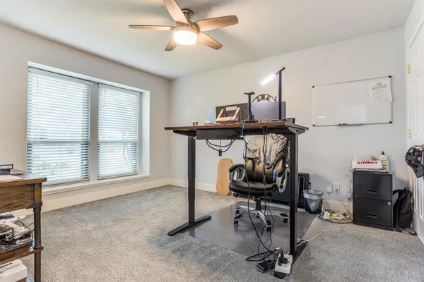 a view of a workspace with furniture and a window