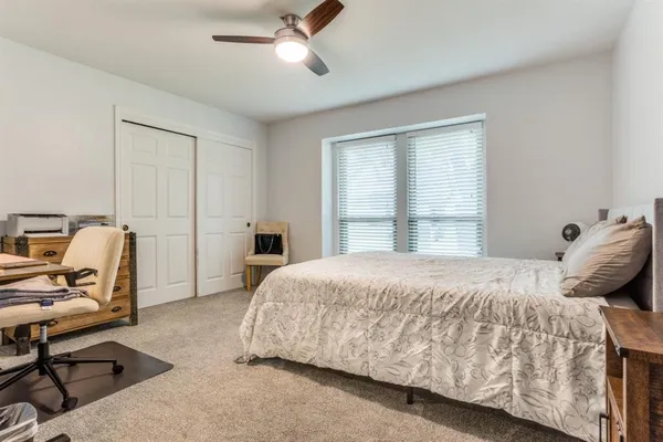 a bedroom with a bed chair and window