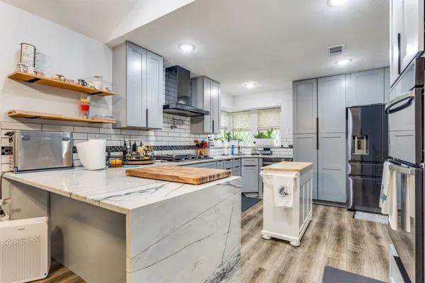 a kitchen with stainless steel appliances granite countertop a sink stove and refrigerator