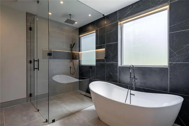 a bathroom with a granite countertop sink mirror and tub