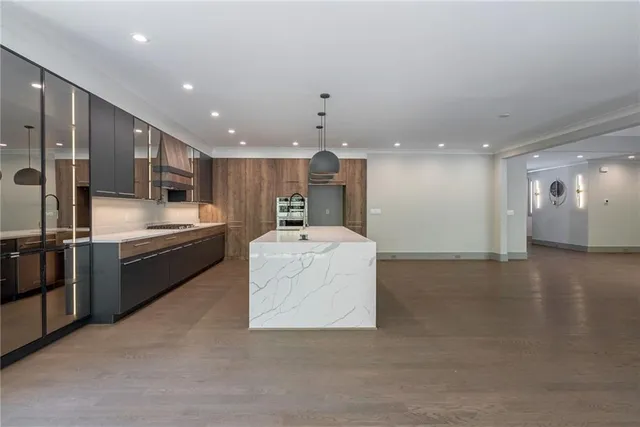 a large kitchen with stainless steel appliances kitchen island a large counter top a stove and a sink