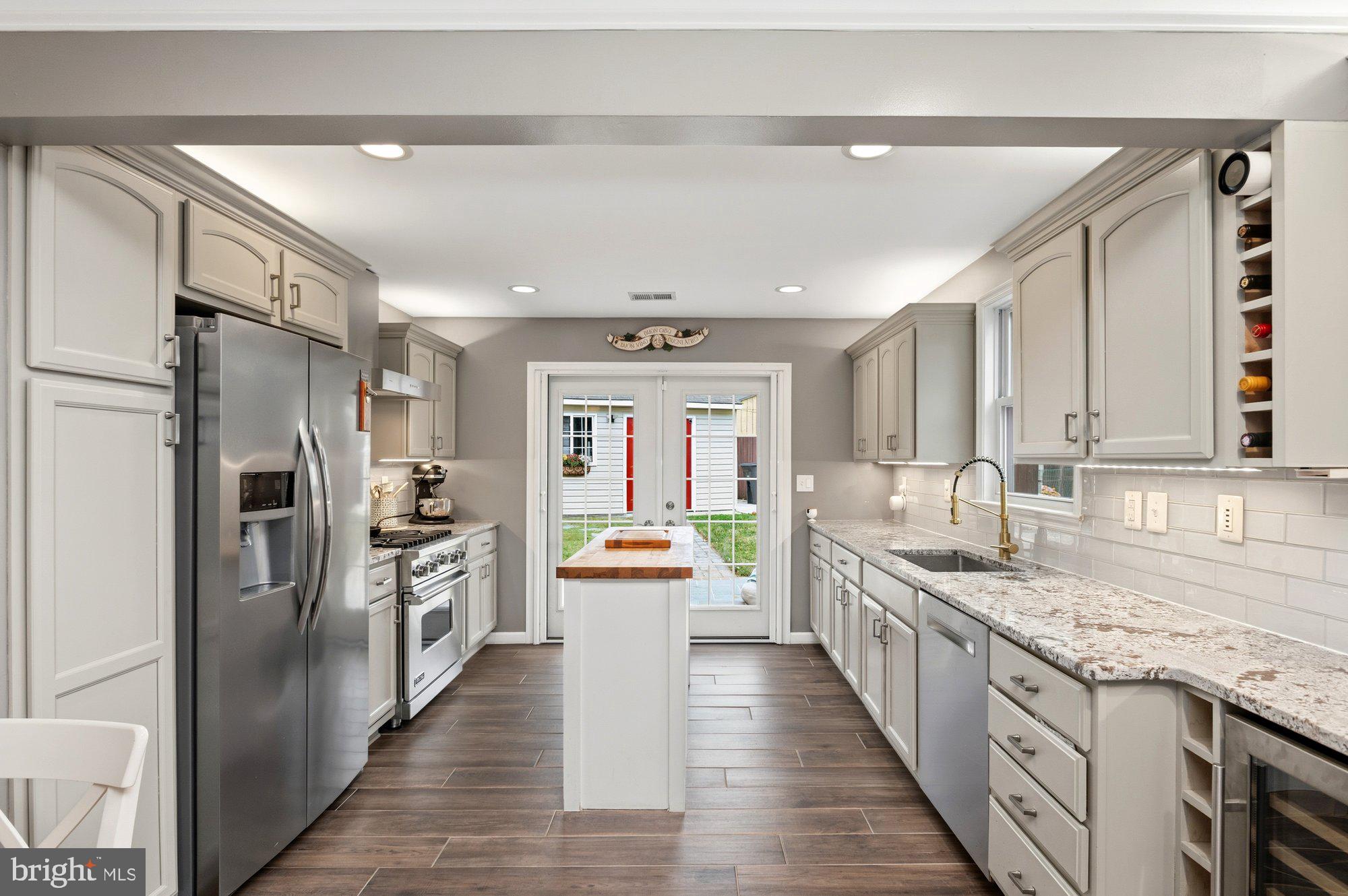 6809 Duke Drive Alexandria, VA 22307 - Photo 5 of 30 a large kitchen with stainless steel appliances granite countertop a lot of counter space and wooden floor