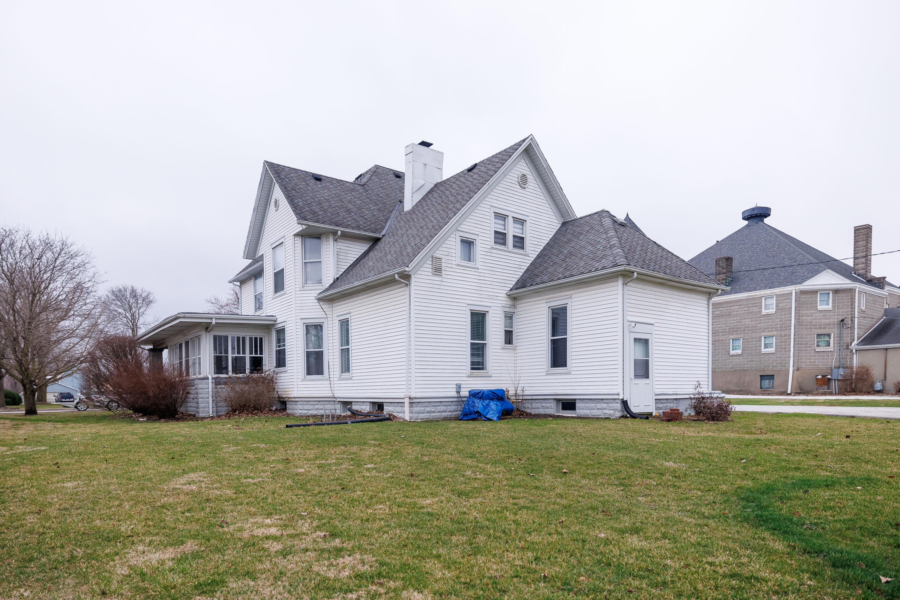 128 East Main Street Brook, IN 47922 - Photo 9 of 68 a view of a white house with a big yard and potted plants