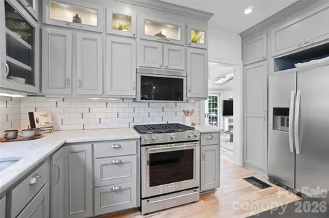 a kitchen with kitchen island granite countertop a sink cabinets and stainless steel appliances
