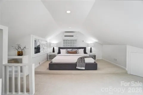 a bed sitting in a bedroom next to a window