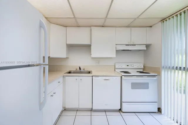 a kitchen with cabinets appliances and a sink