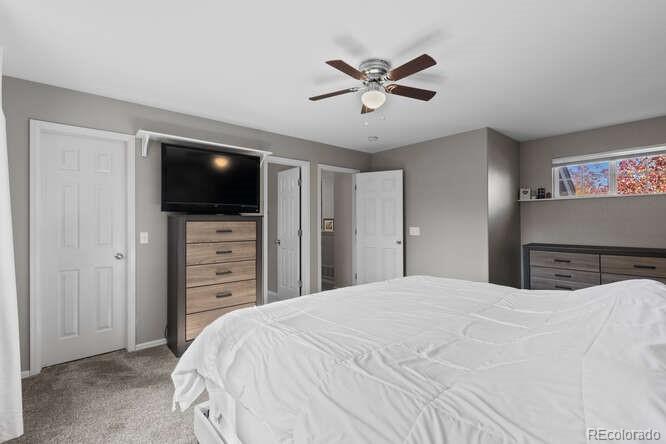 8354 Dove Ridge Way Parker, CO 80134 - Photo 17 of 38 a bedroom with a bed and a flat screen tv