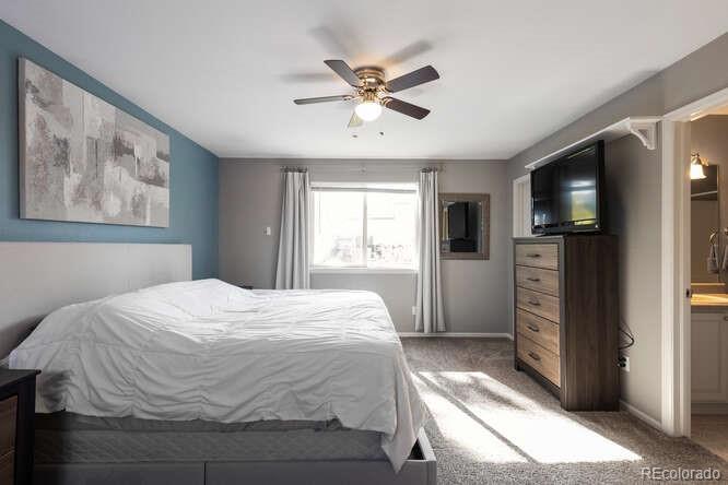 8354 Dove Ridge Way Parker, CO 80134 - Photo 19 of 38 a bedroom with a large bed a flat tv screen and a window