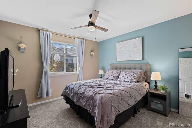 8354 Dove Ridge Way Parker, CO 80134 - Photo 24 of 38 a bedroom with bed and a flat tv screen
