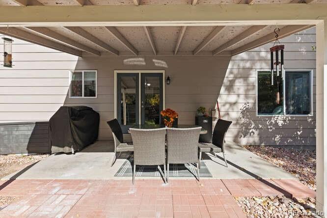 8354 Dove Ridge Way Parker, CO 80134 - Photo 33 of 38 a view of a patio with a table and chairs and floor to ceiling window
